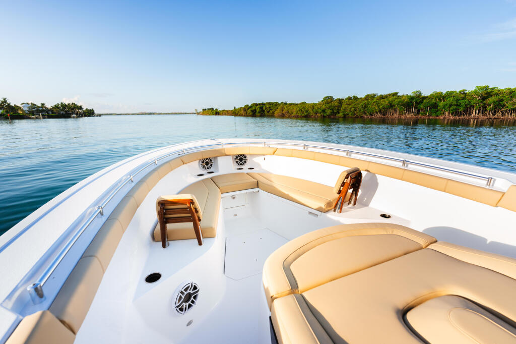Spacious bow seating and lounge area of a white center console boat on calm tropical waterway