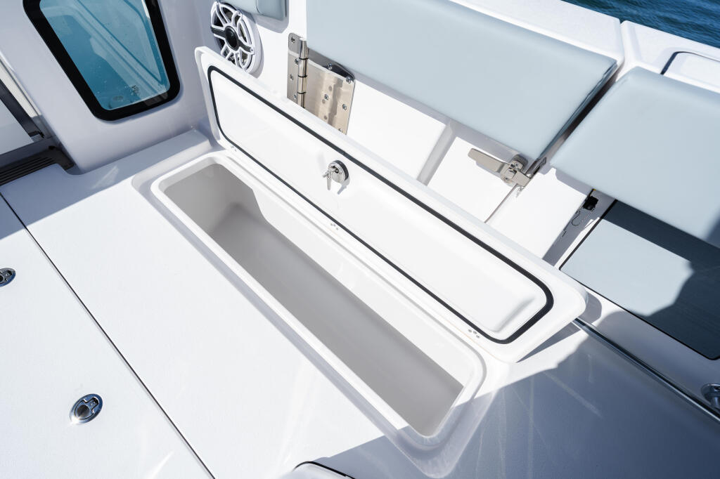 Open storage compartments and livewell with chrome hardware on the boat's side