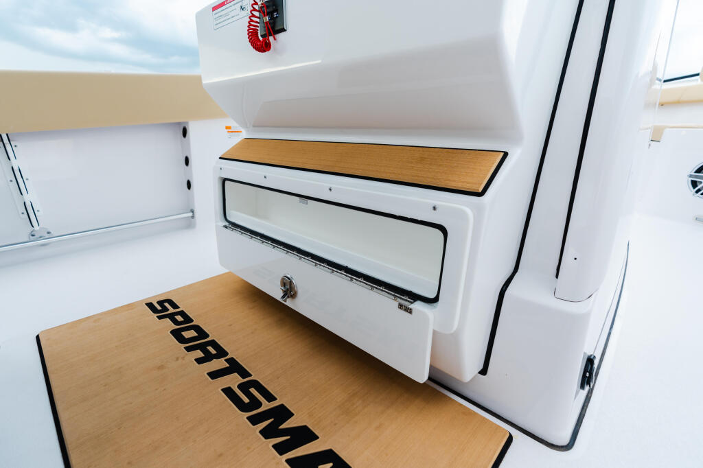 Cabin interior with wooden deck, storage locker, and white cabinetry aboard a sportfish boat