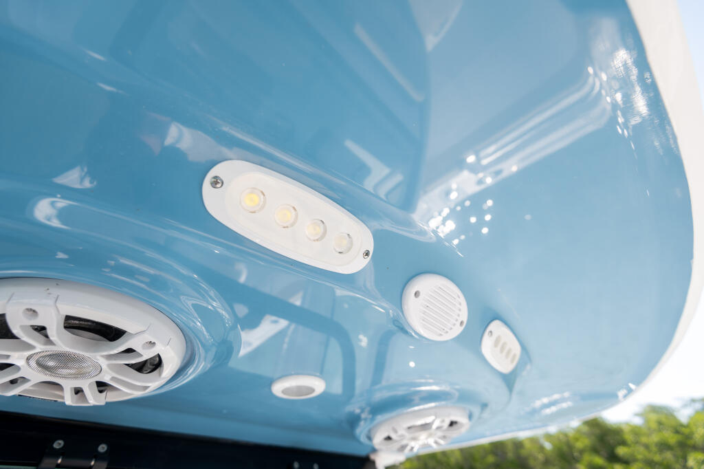 Hardtop interior showing white LED spreader lights and ventilation fixtures against blue gel coat