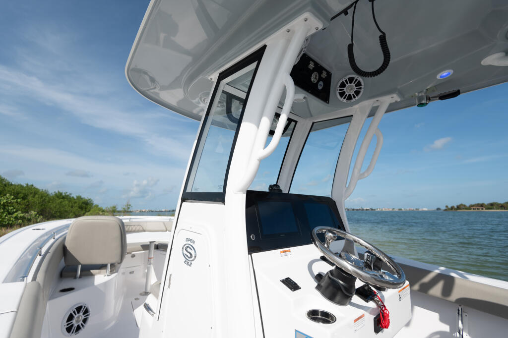 Center console boat helm with open windshield and integrated electronics overlooking calm turquoise waters