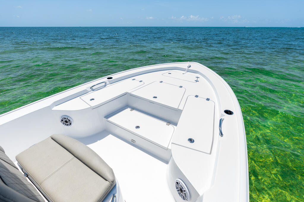White center console boat with open bow casting deck and seating anchored in shallow turquoise water