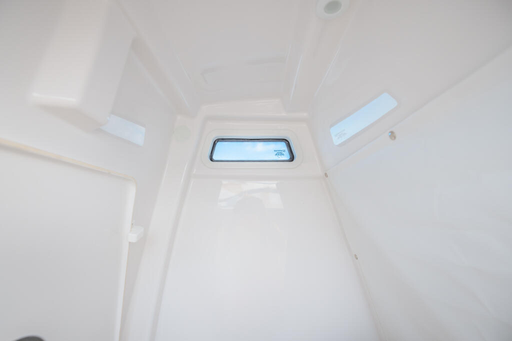 Bright cabin interior with recessed lighting and a rectangular window showing blue sky