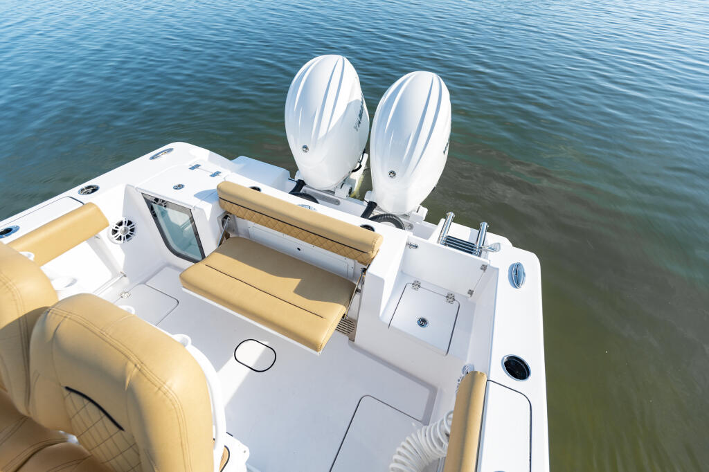 Overhead view of center console boat's stern with tan convertible seating and dual outboard engines