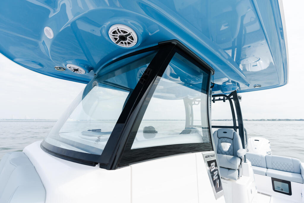 Blue hard-top with black frame and large windshield on white center console boat at anchor