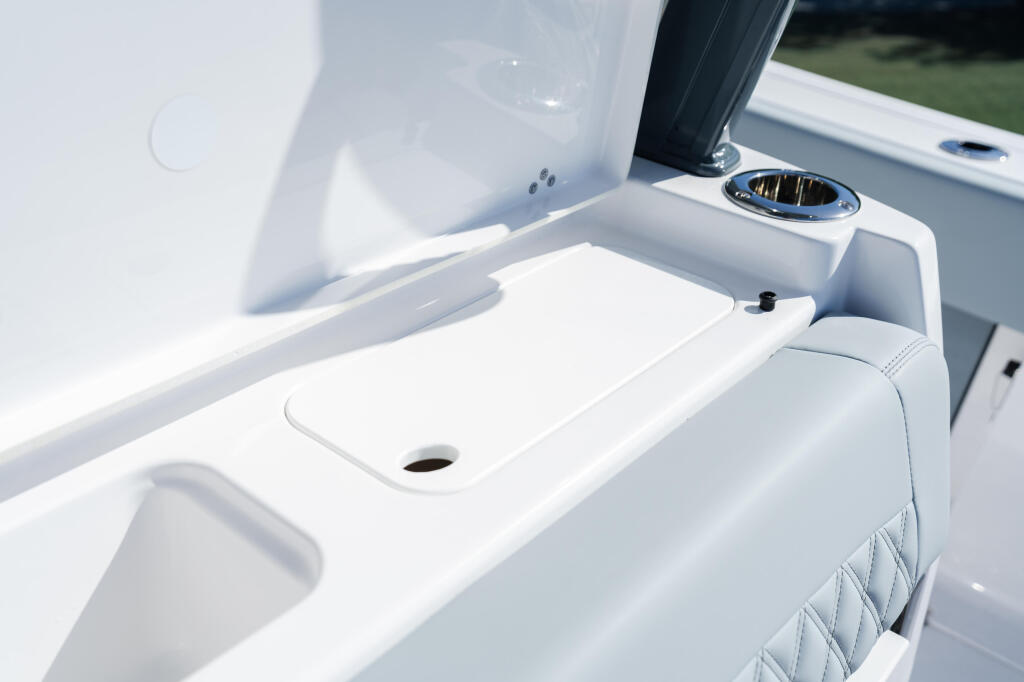 White fiberglass console with cup holder and ventilation detail on boat deck