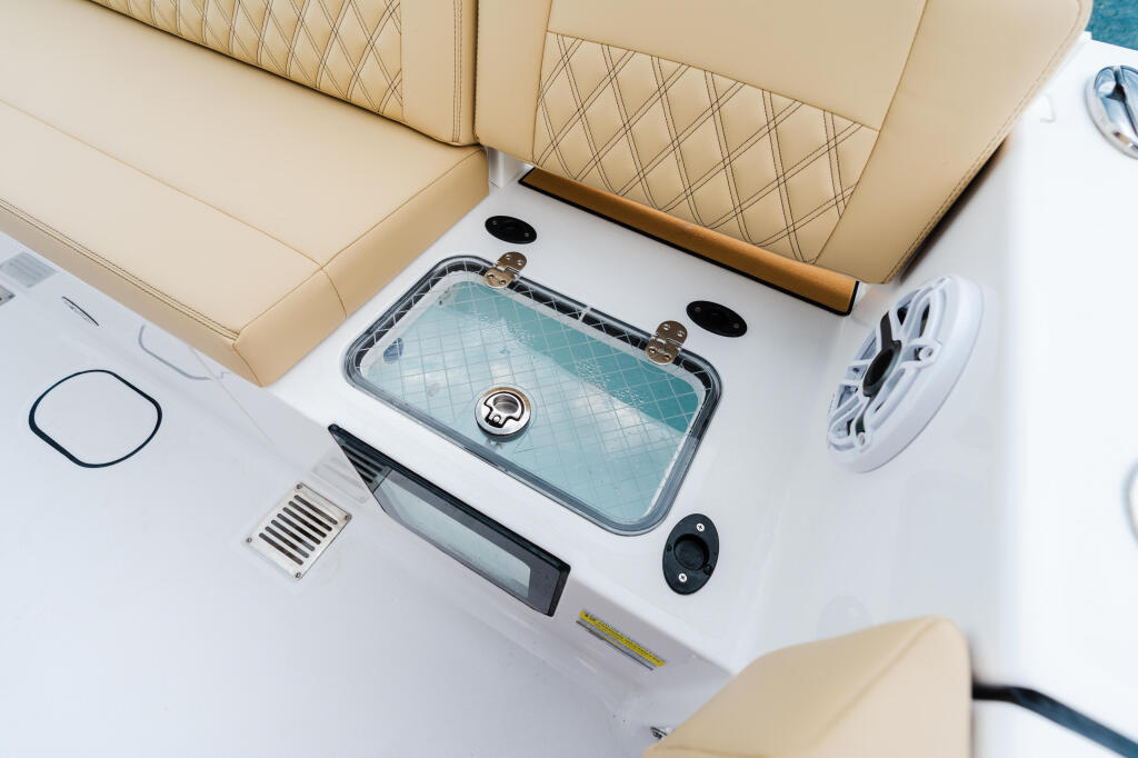 Overhead view of boat console with cream leather seating, turquoise livewell, and electronic controls