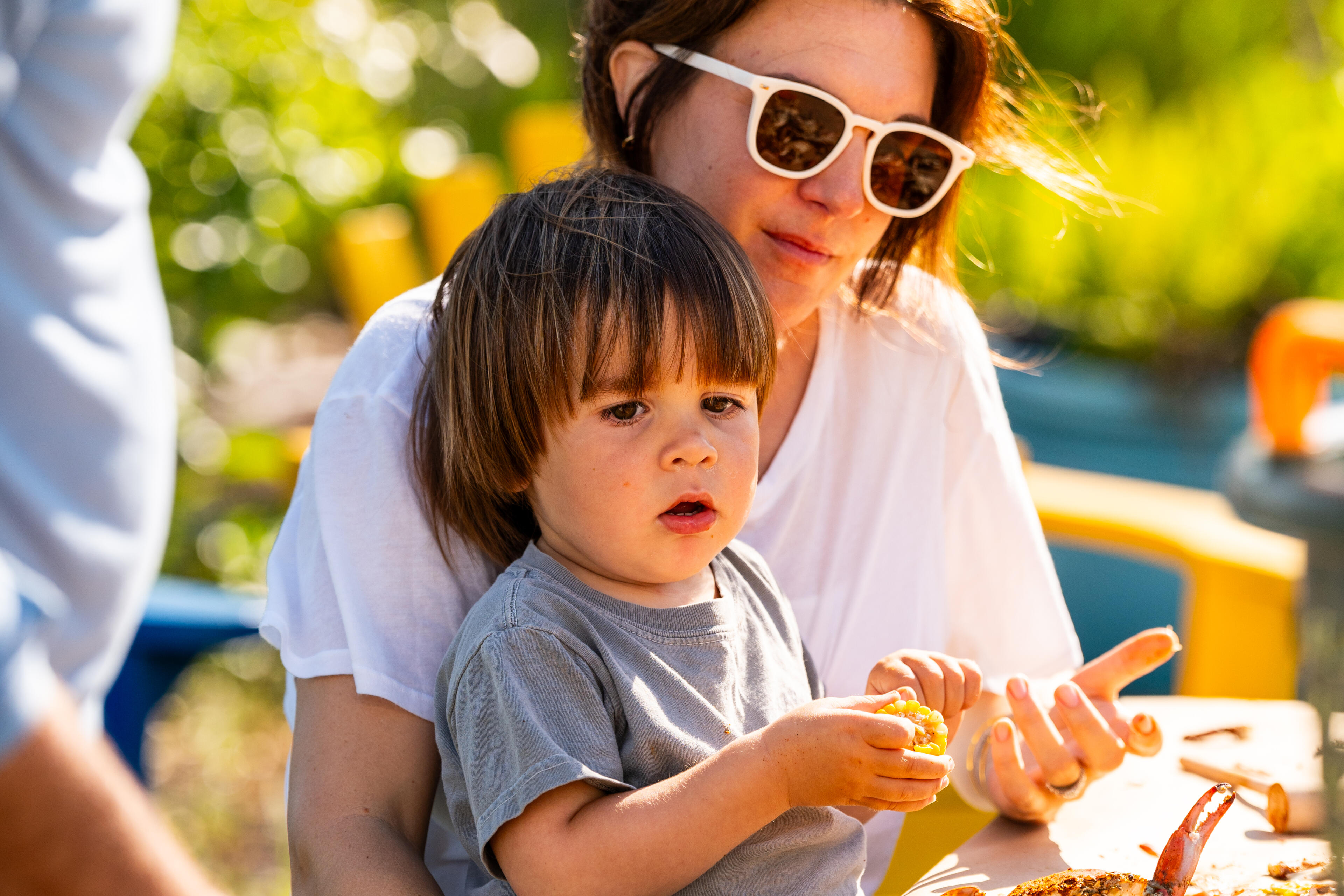 Woman and young child enjoying a seafood meal outdoors in a sunny garden setting