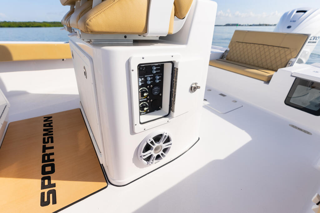 Sportsman boat console showing electronics panel, speaker, and control switches with yellow seating visible