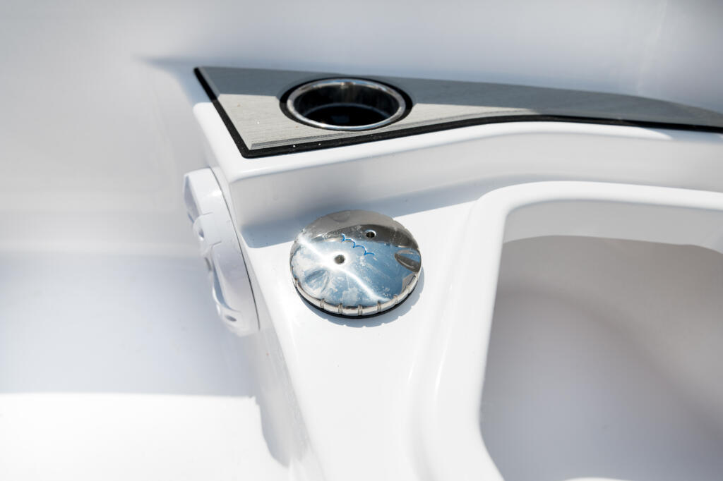 Close-up of boat helm compass and freshwater washdown system with chrome detail