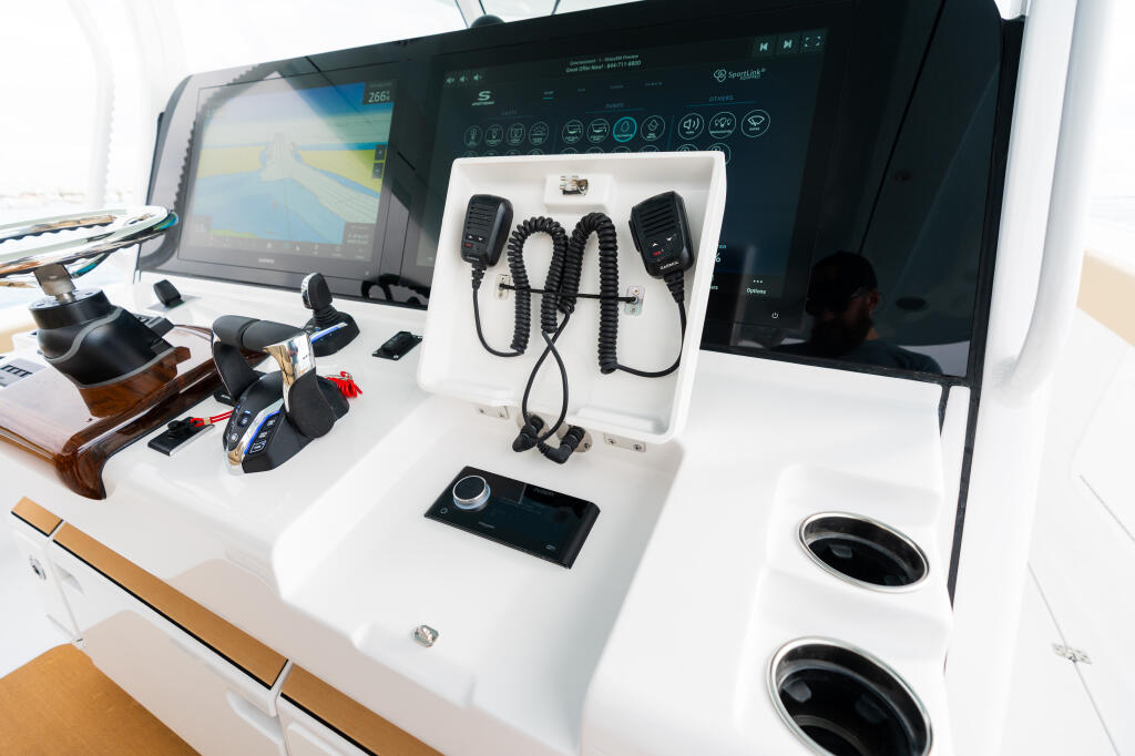 Helm console with dual displays, VHF radio equipment with coiled microphone cables, and integrated navigation electronics