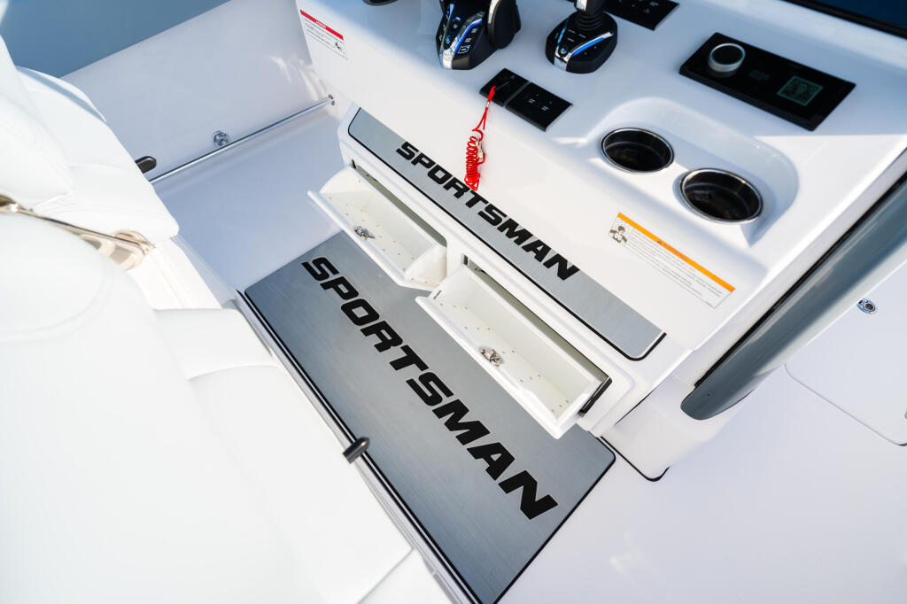 Sportsman boat helm station with control panels, electronic gauges, and dual engine controls on white console