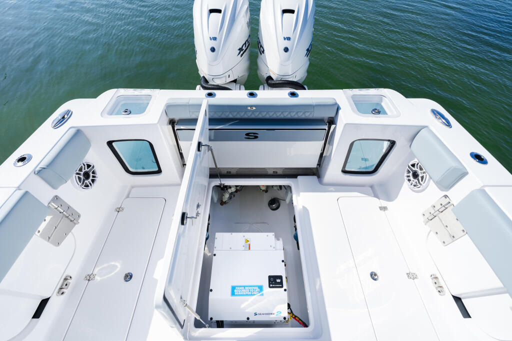 Overhead view of open center console boat showing dual helm seating, storage compartments, and twin outboard engines