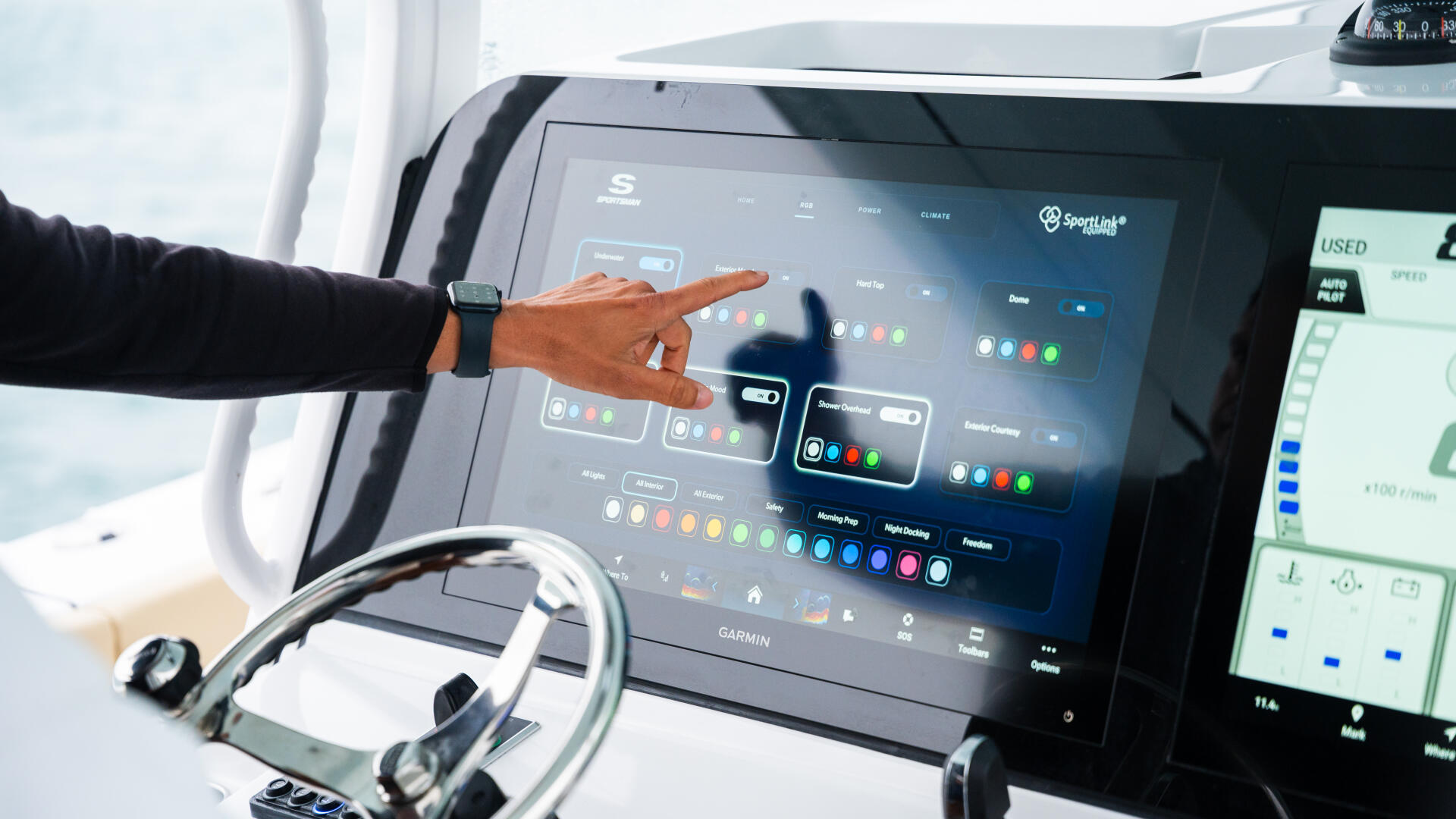 Captain operating advanced Garmin electronics and navigation system at the helm of a center console boat