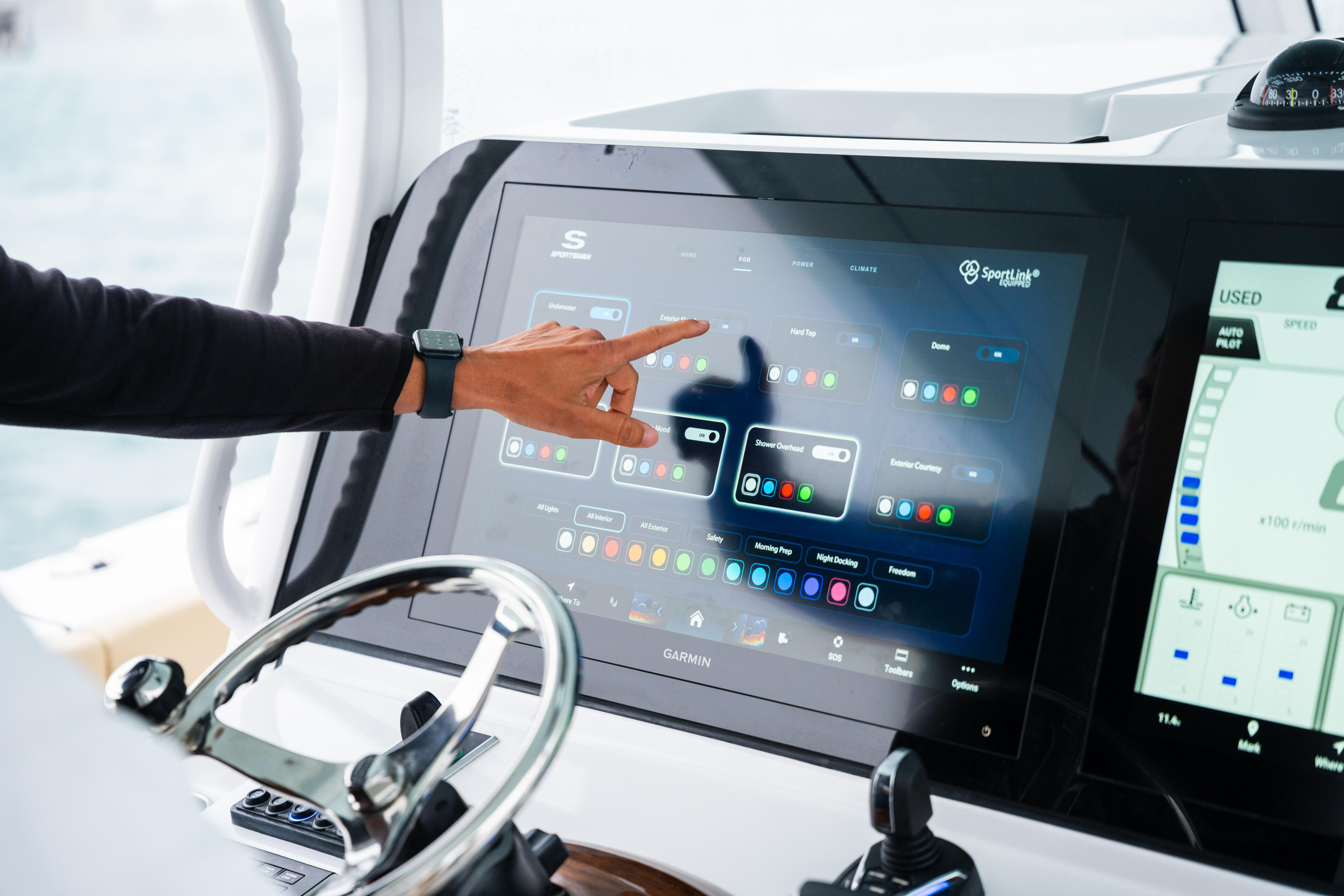 Captain operating advanced Garmin electronics and navigation system at the helm of a center console boat