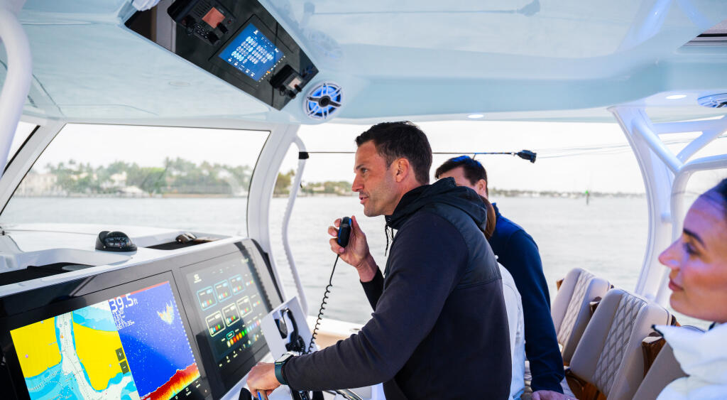 Couple operating helm with advanced electronics and VHF radio in center console cabin