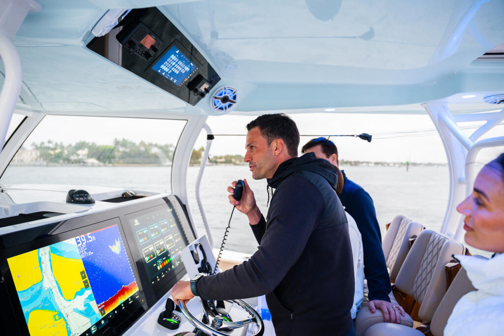 Couple operating helm with advanced electronics and VHF radio in center console cabin