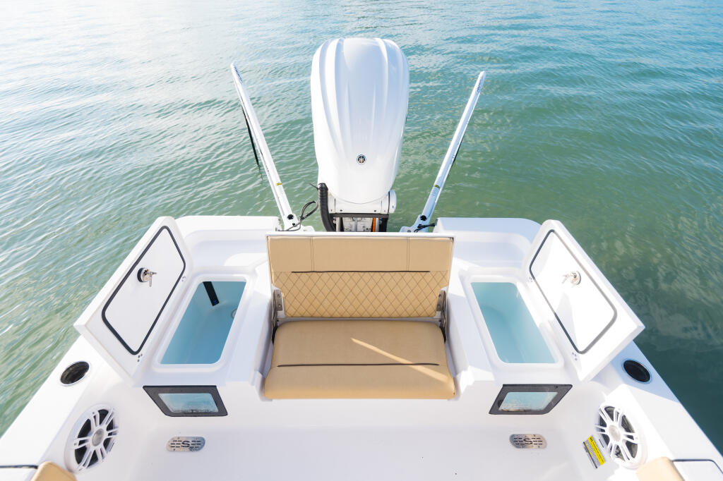 Overhead view of center console boat showing dual electronics, beige seating, and dual engines in calm turquoise water