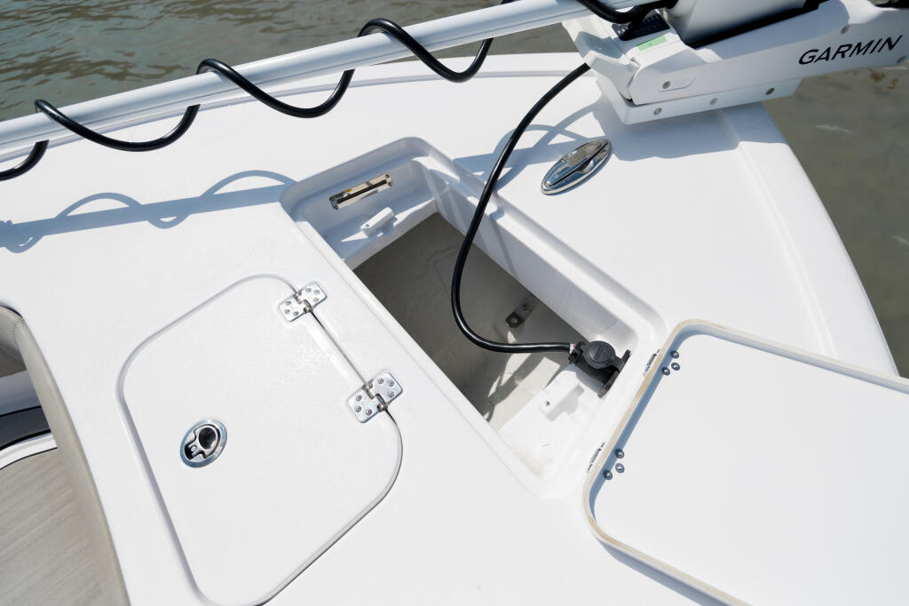 Boat's starboard console area with Garmin electronics, rod holders, and hatches for storage
