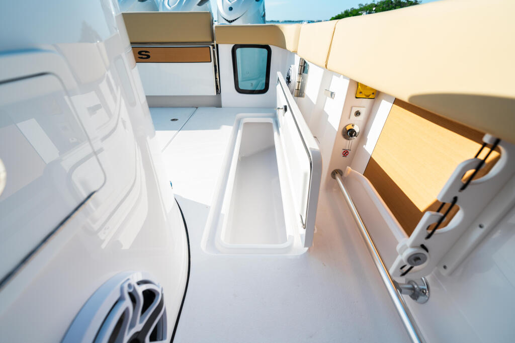 Overhead view of a boat's cabin with storage lockers, seating, and access to the helm area