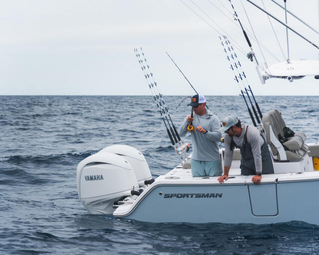 Two anglers fishing offshore with multiple rod holders rigged on a Sportsman center console boat