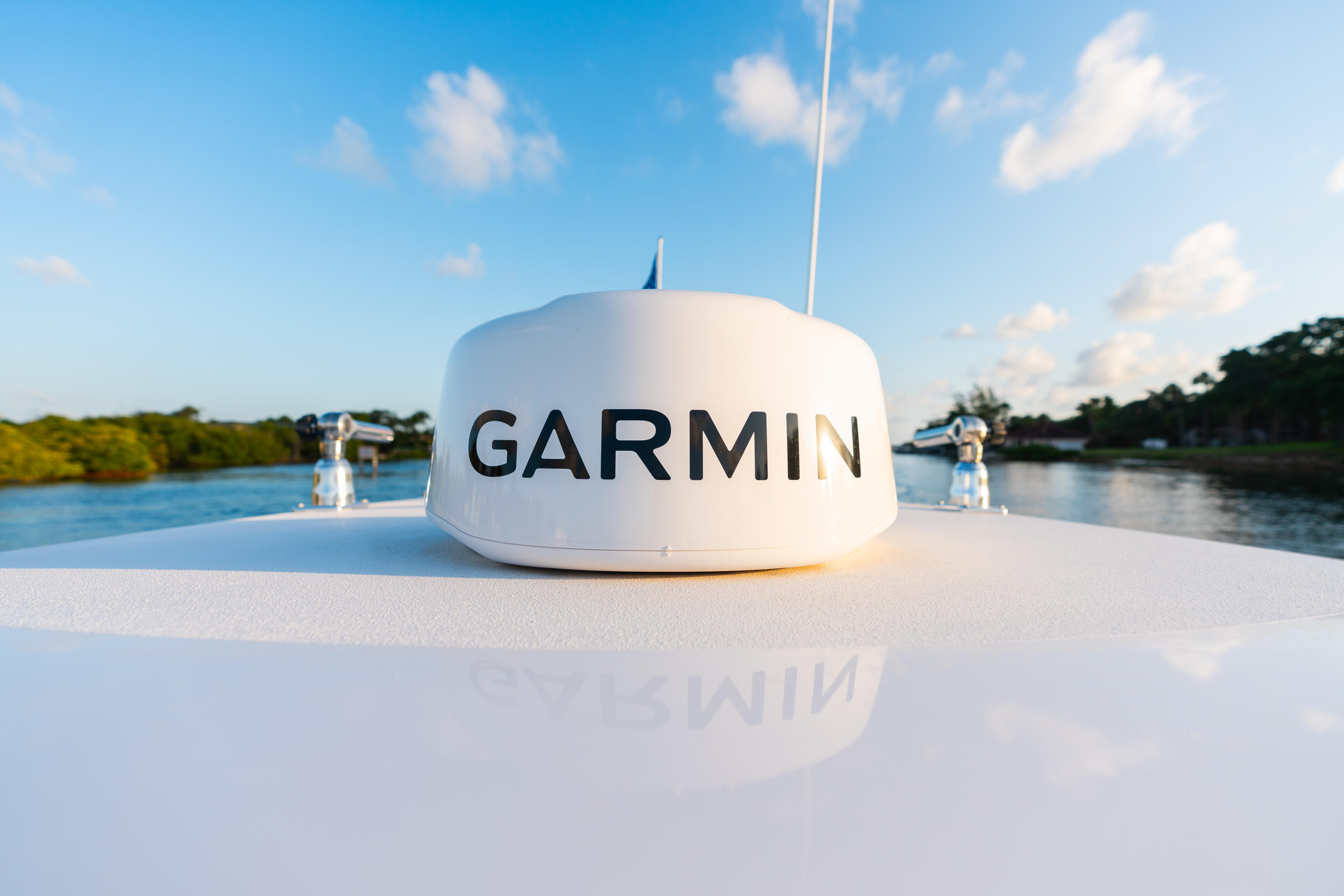 Garmin GPS dome antenna mounted on a boat's hardtop with waterway and mangroves in background