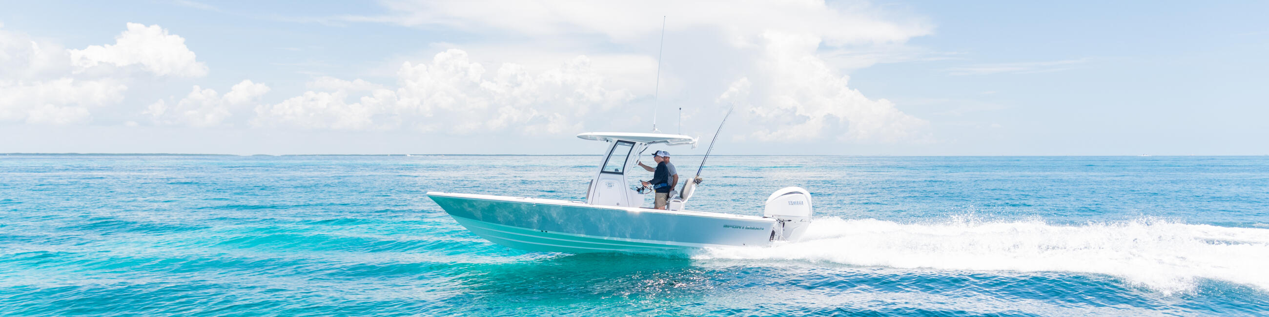 Turquoise water with angler fishing from a running center console boat near the beach
