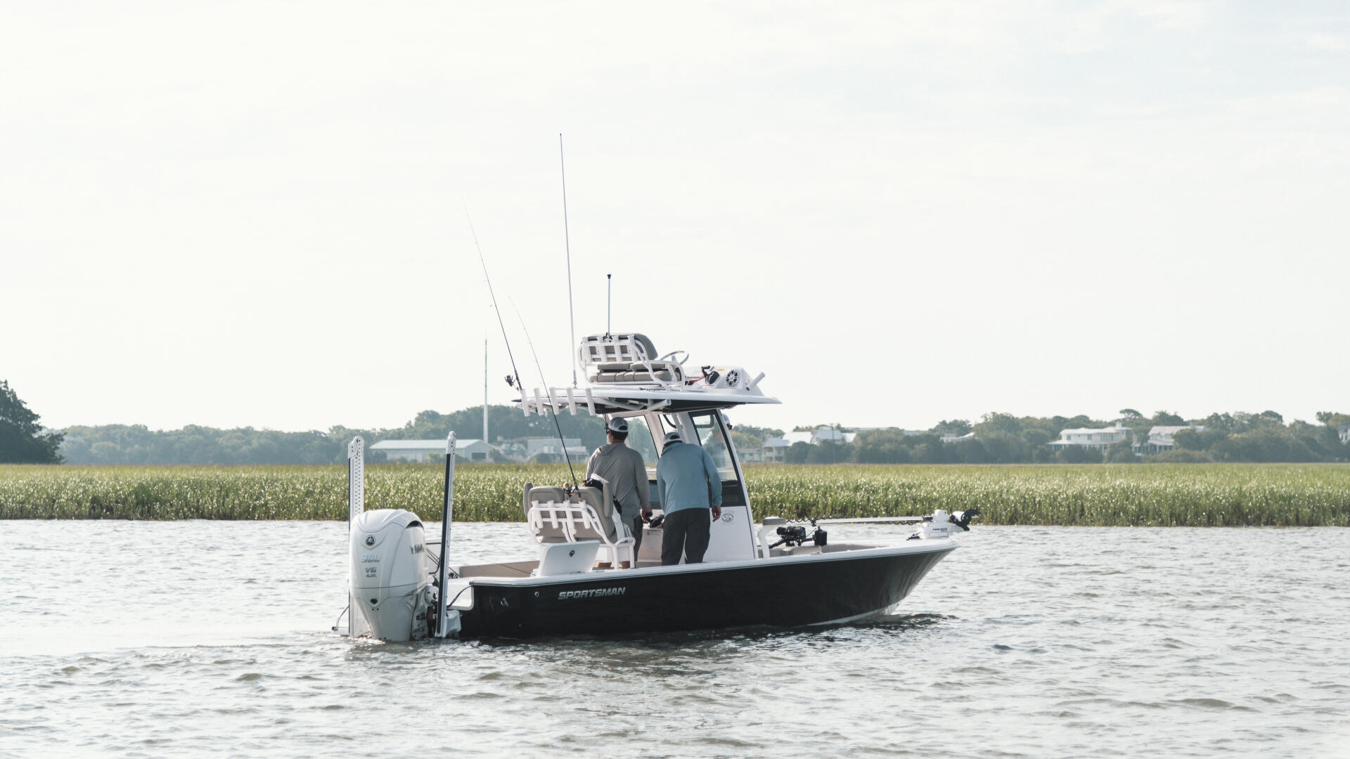 Sportsman boat with hard-top and fishing rigging anchored in shallow marsh waters