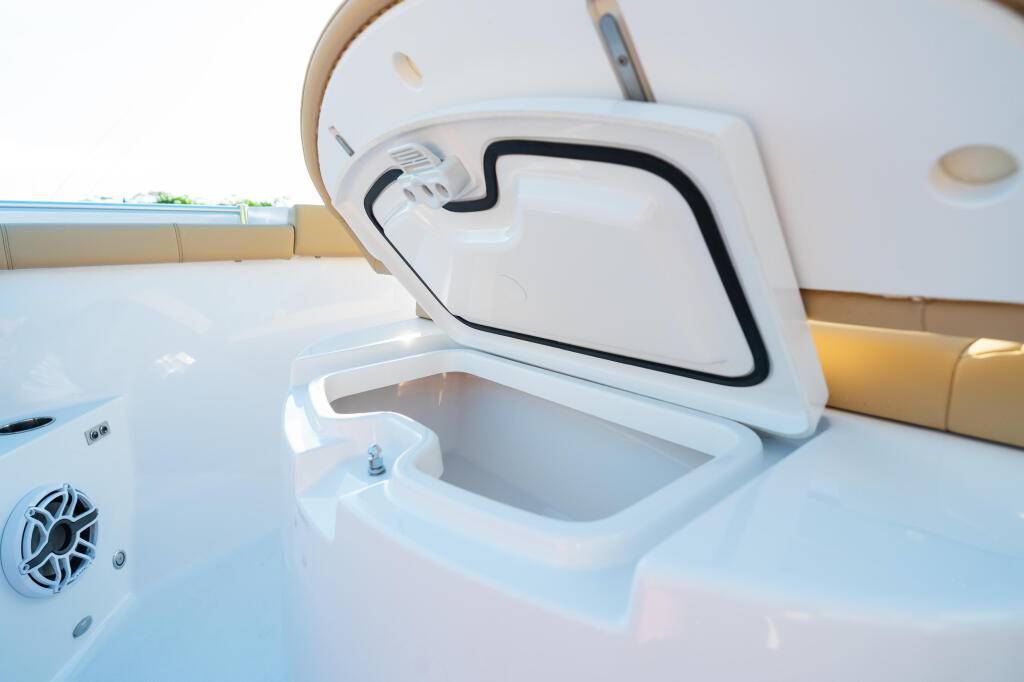 Open livewell storage compartment with aerator on white fiberglass boat deck