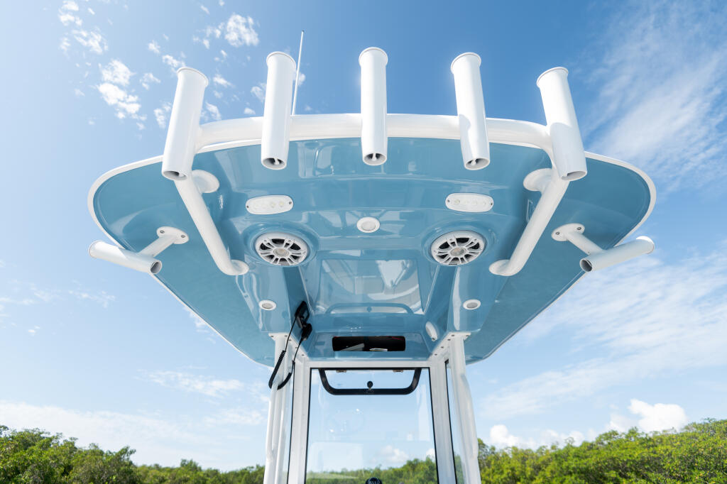 Overhead view of a center console boat's hard-top frame with white antennas and equipment against blue sky