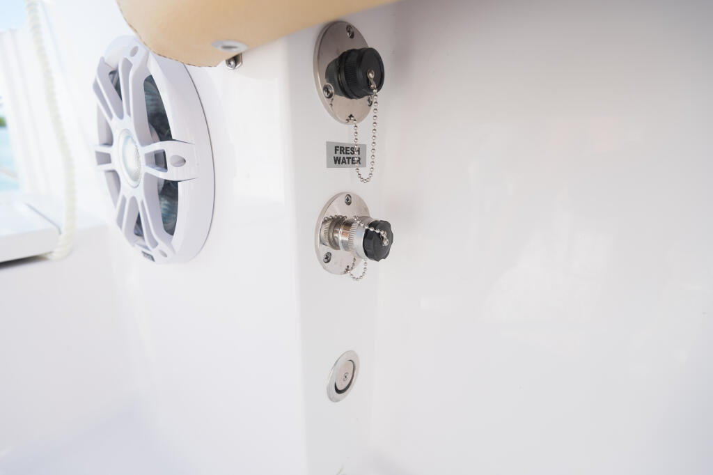 Freshwater washdown system with pull-chain valve and marine speakers mounted on cabin wall