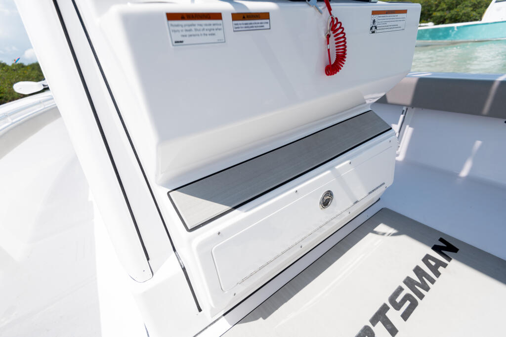 Open livewell compartment on white center console boat with gray interior seating visible