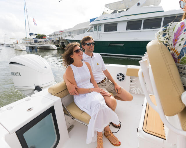 Couple relaxing in tan seating area of center console boat at marina