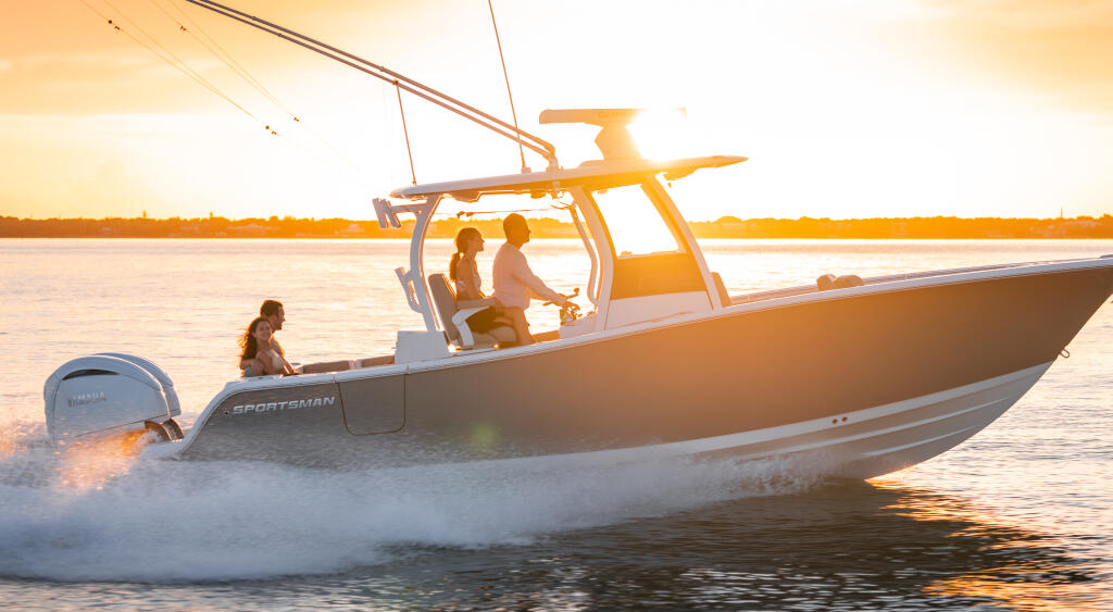 Center console boat running through shallow water at sunset with passengers aboard