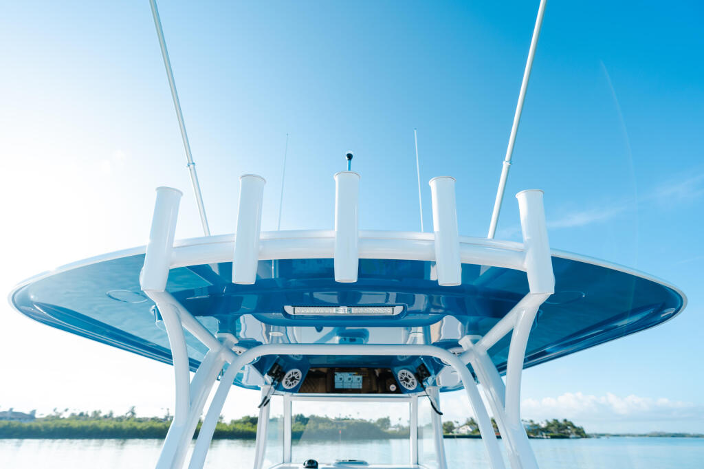Overhead view of boat's hard-top canopy with white frame and blue tinted panels against clear sky