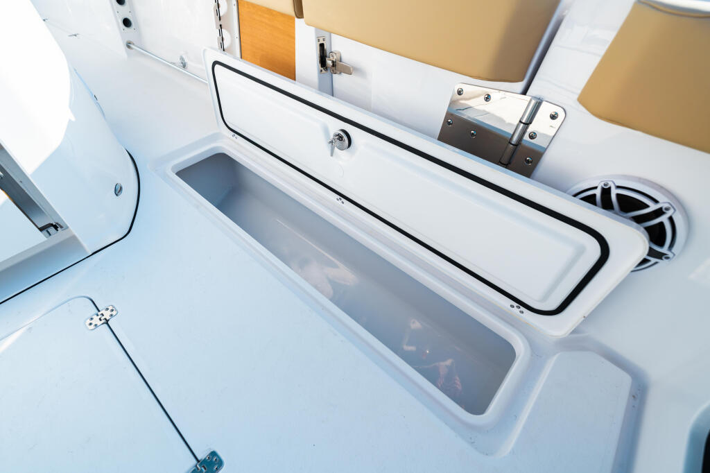 Open livewell and storage compartments on the boat's starboard side with white gelcoat finish