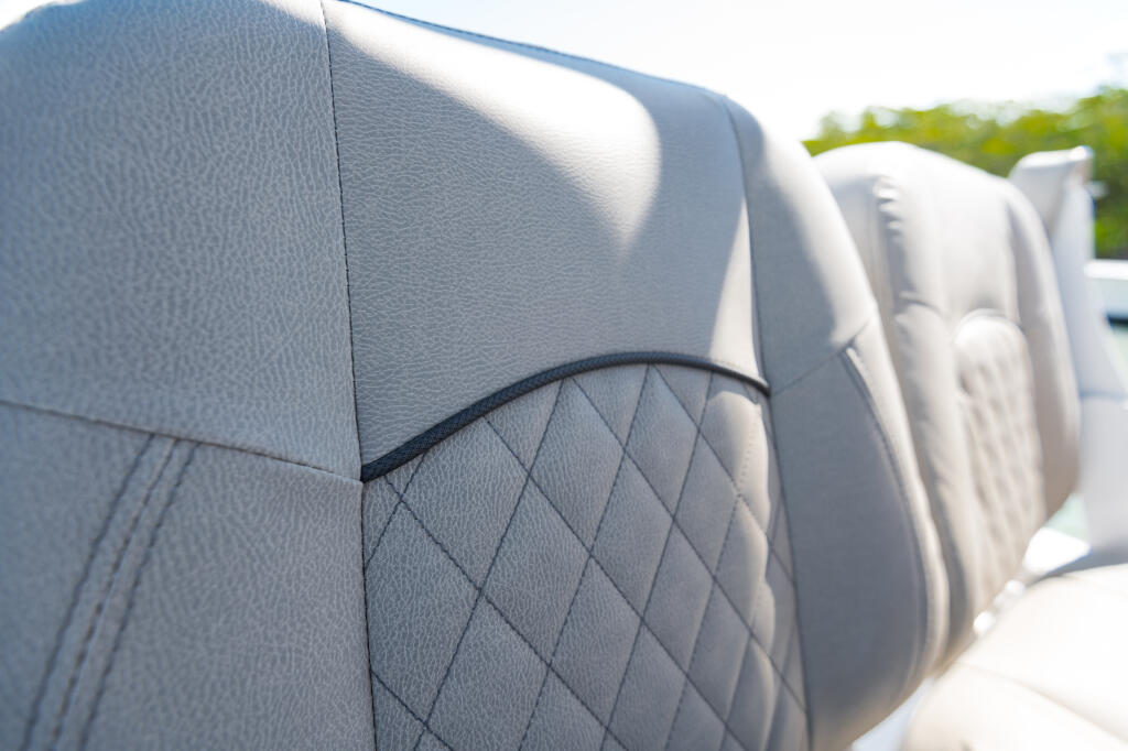 Boat seating with quilted gray marine upholstery and piping detail in sunlight