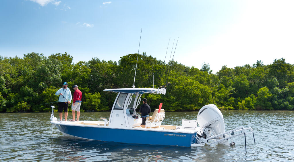Fishing boat with passengers anchored in shallow coastal waters surrounded by mangrove trees