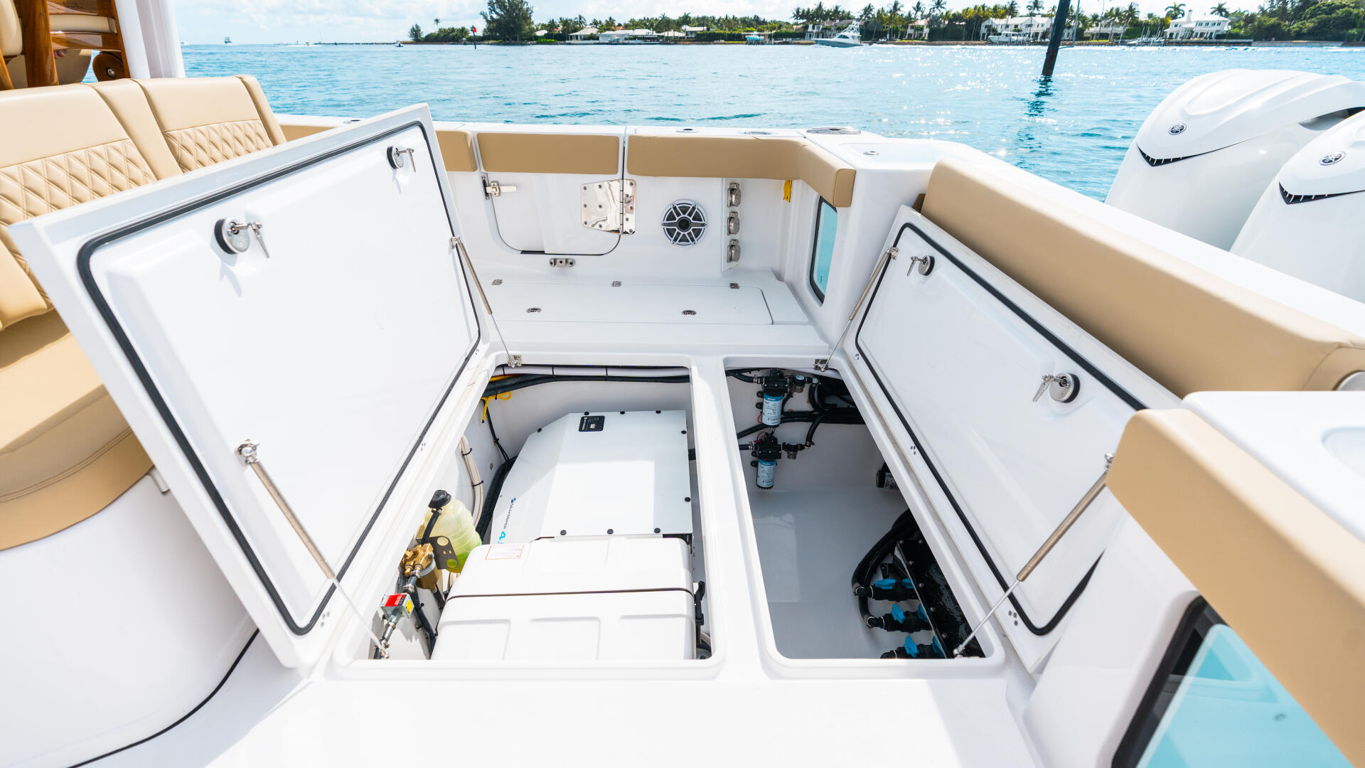 Open center console helm with dual storage compartments and tropical island anchorage in background