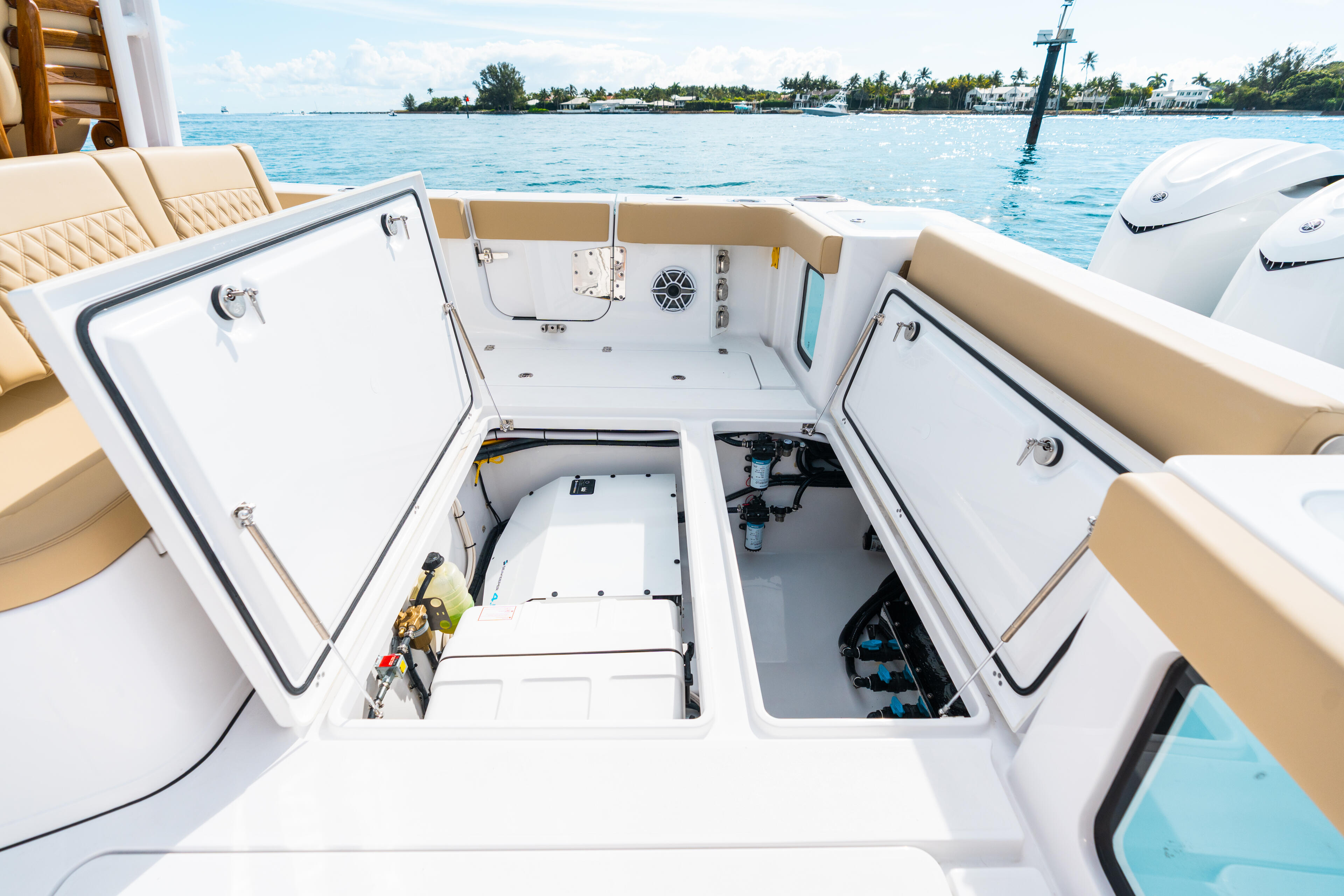 Open center console helm with dual storage compartments and tropical island anchorage in background