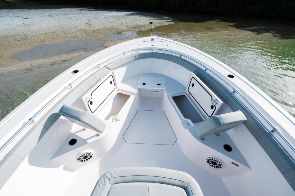 Center console view of white boat beached on sandbar with shallow water and mangroves