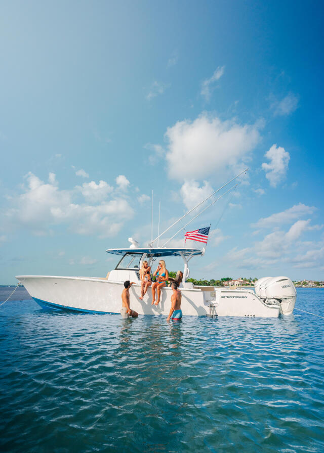 Couple enjoying a boat day in shallow turquoise waters near a sandbar with American flag flying