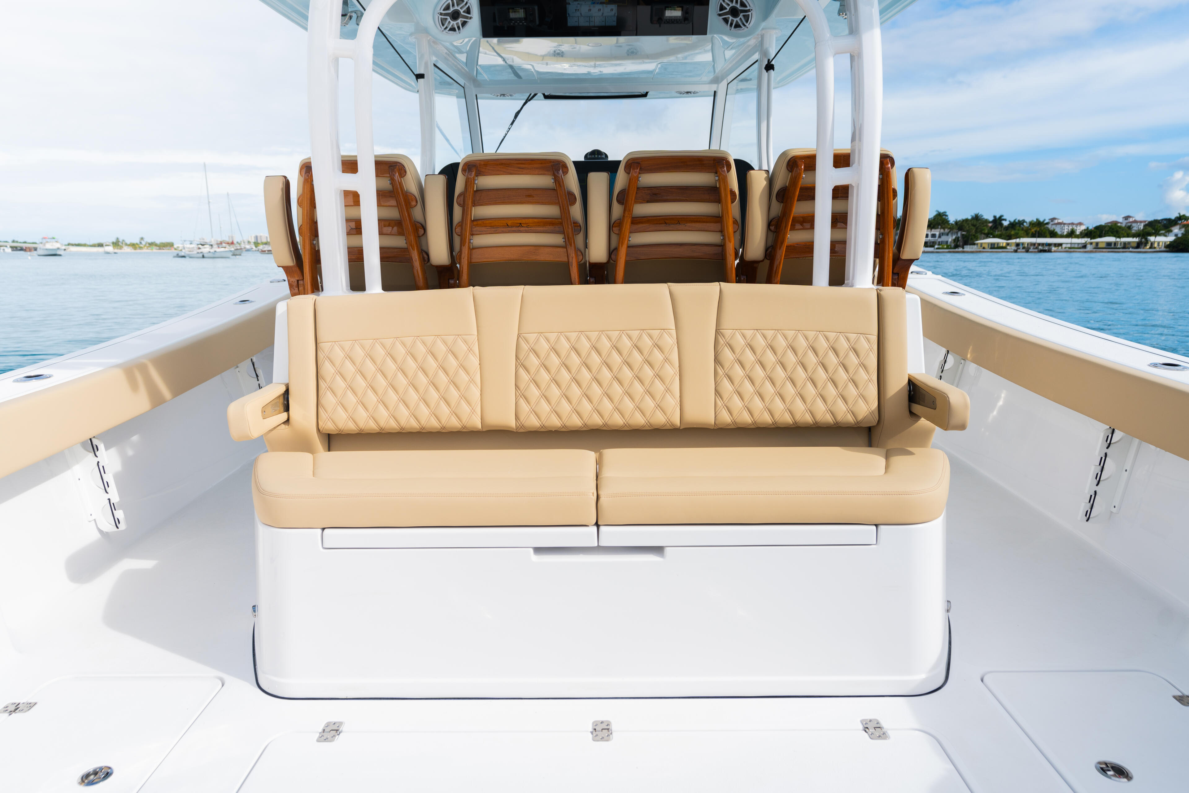 Cream-colored seating with quilted cushions facing the water, backed by a hard-top canopy on a center console boat