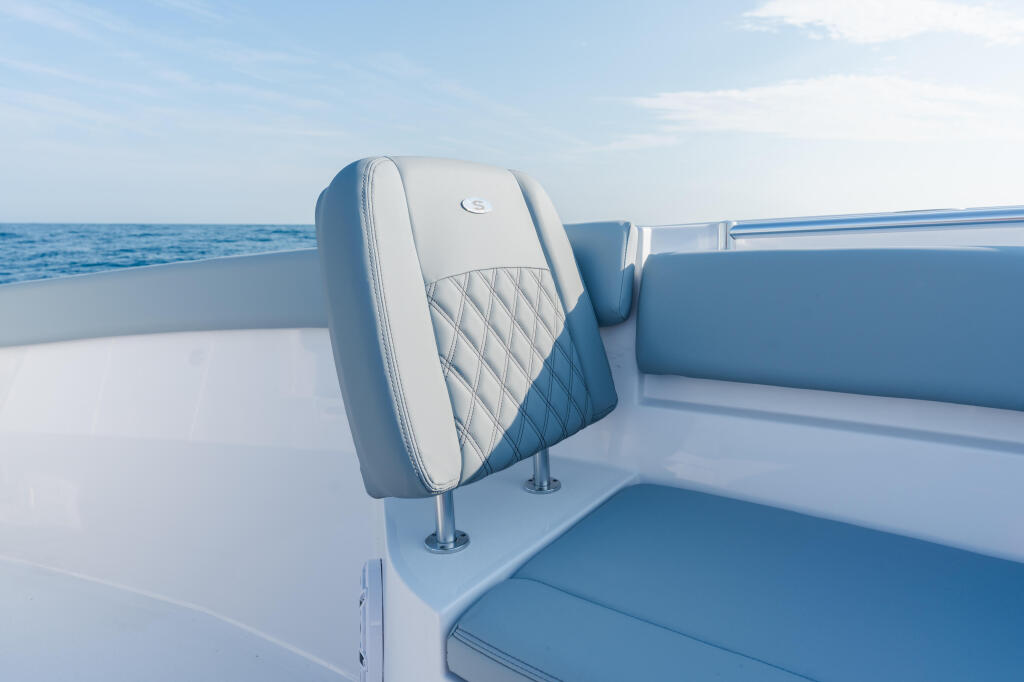 Quilted blue and white boat seating with chrome accents overlooking open ocean water