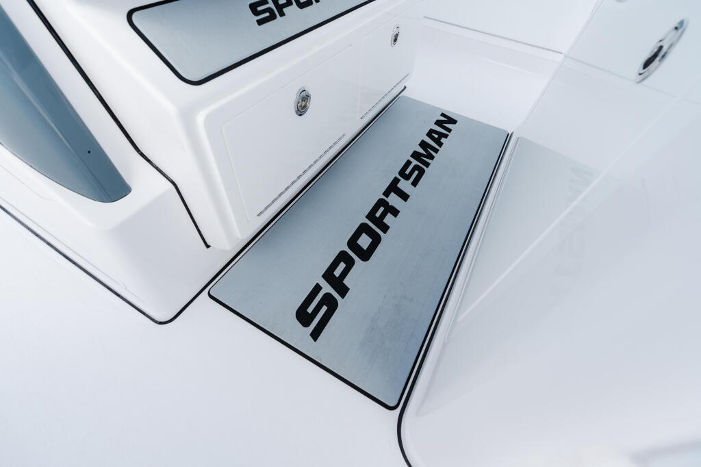 Sportsman platform detail on white fiberglass boat hull with stainless steel trim
