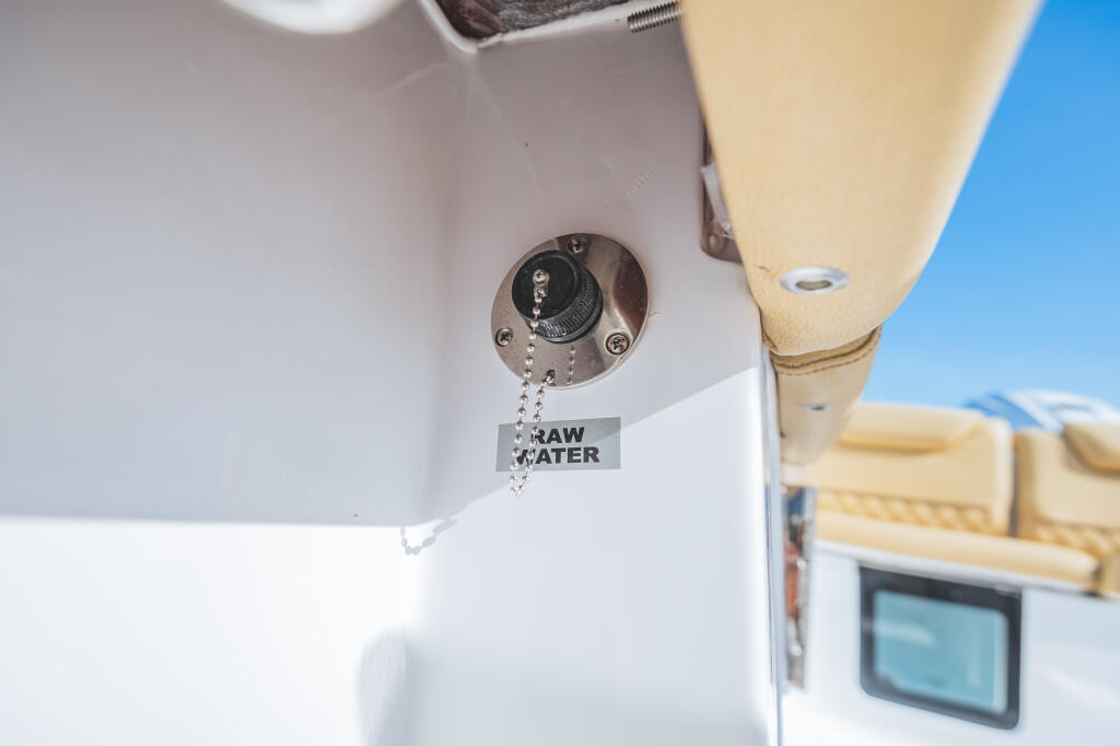 Raw water washdown valve detail on boat console with clear blue sky in background