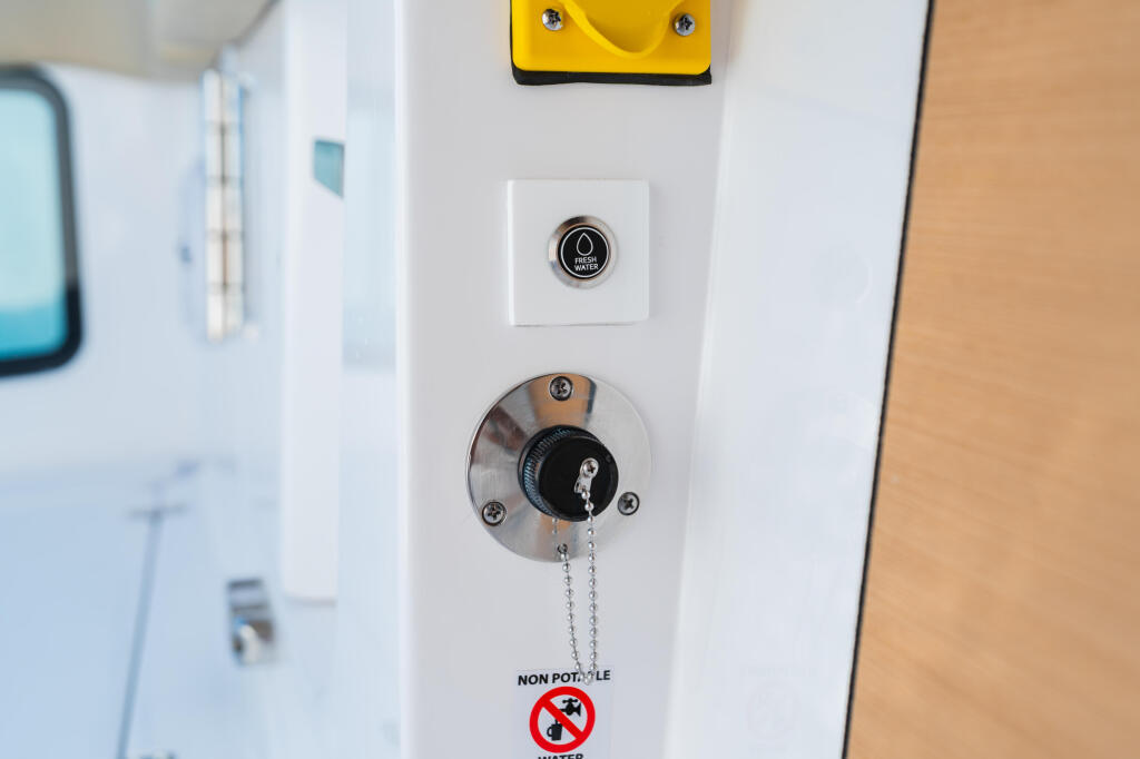 Boat cabin interior control panel with engine ignition switch, horn button, and non-potable water warning label