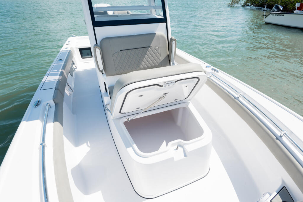 White center console boat with open storage compartment and quilted captain's seat in shallow turquoise water
