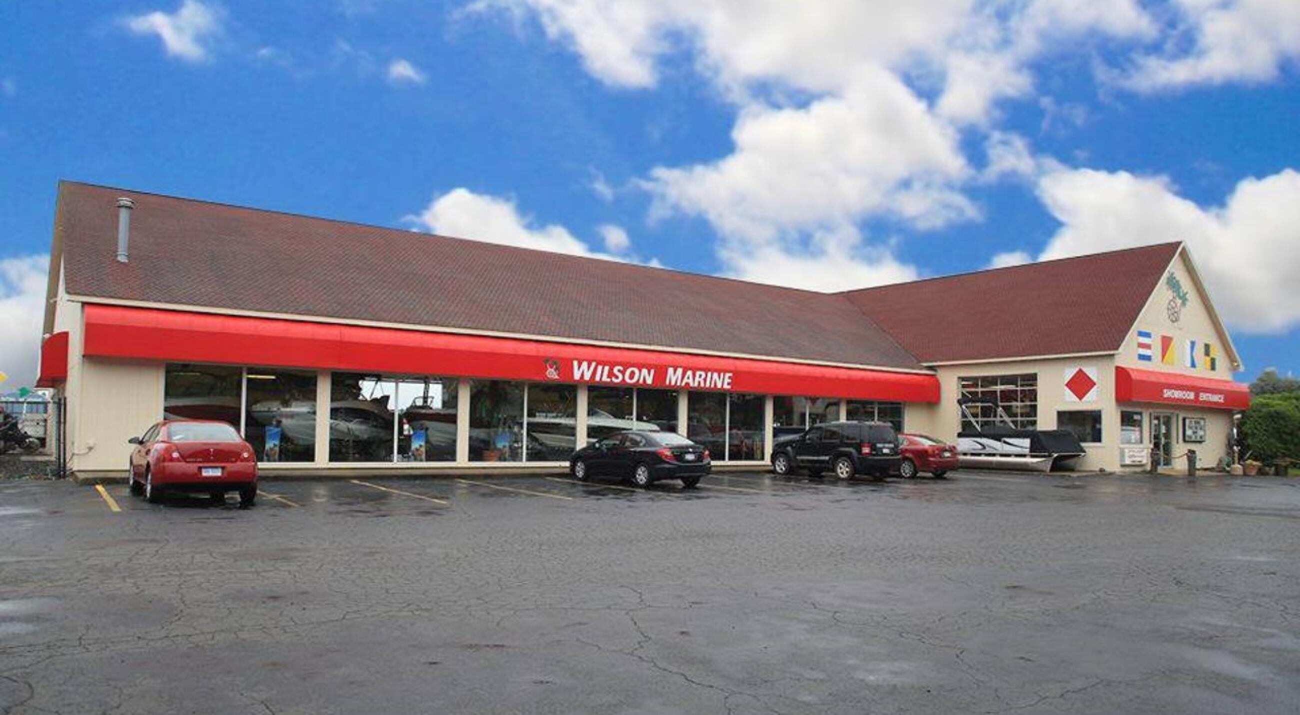 Wilson Marine storefront in Howell with red awning and parking lot on a sunny day