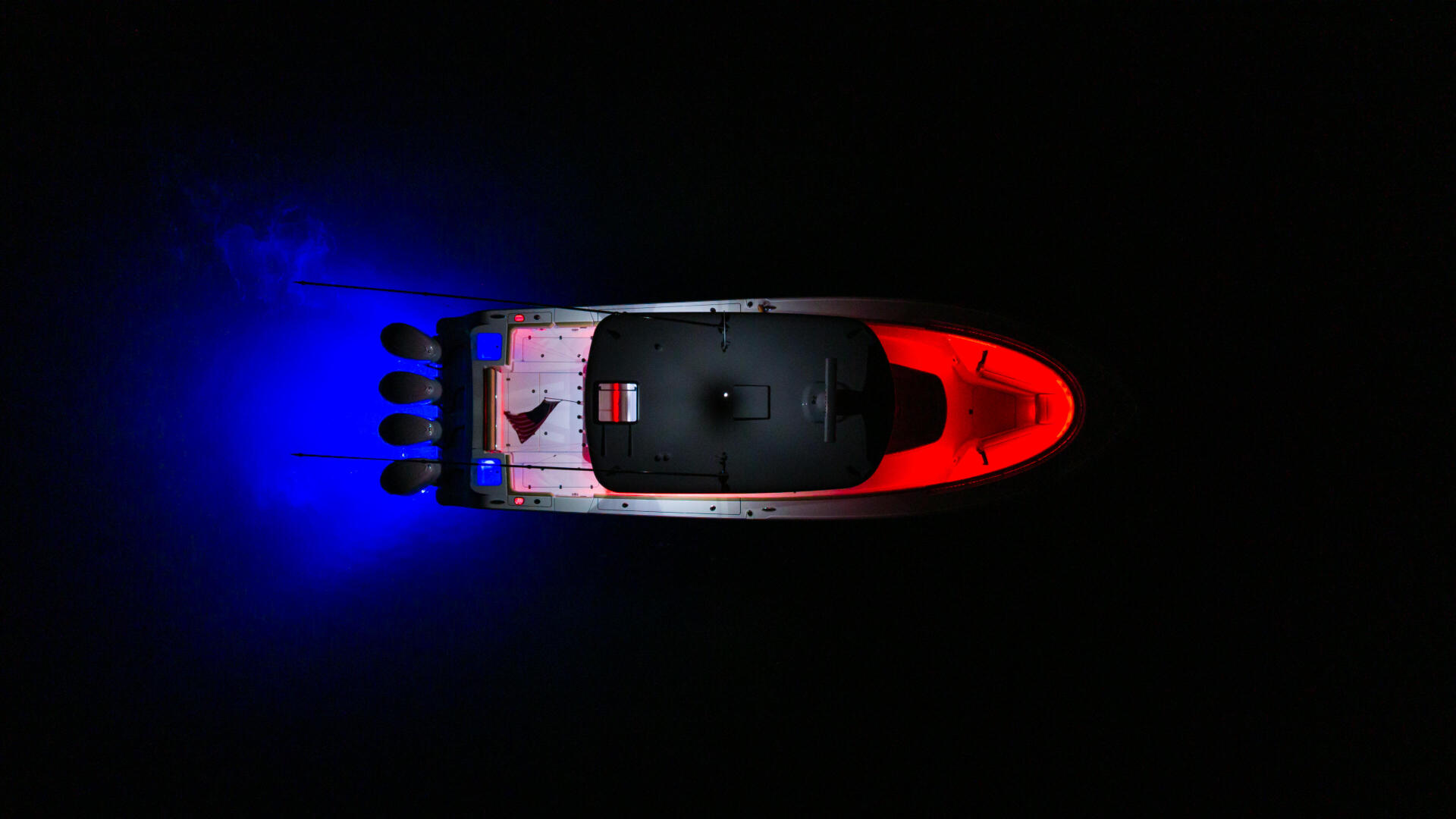 Red and black center console boat viewed from above with blue RGB lighting illuminating the water